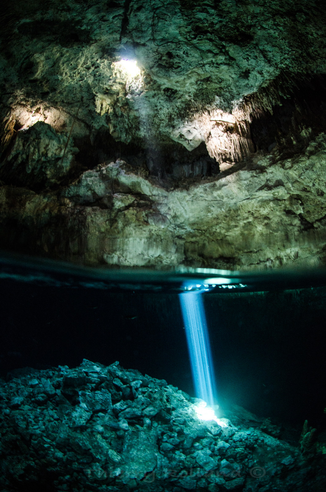 Rayons de lumière mi air-mi eau dans un cenote